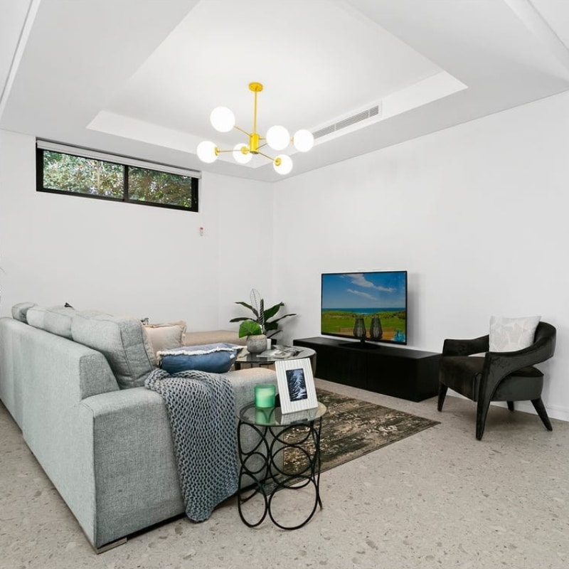 Living room with a grey couch at 12 Pillars Place, Matraville, styled and built by Sydney East Building & Renovations.