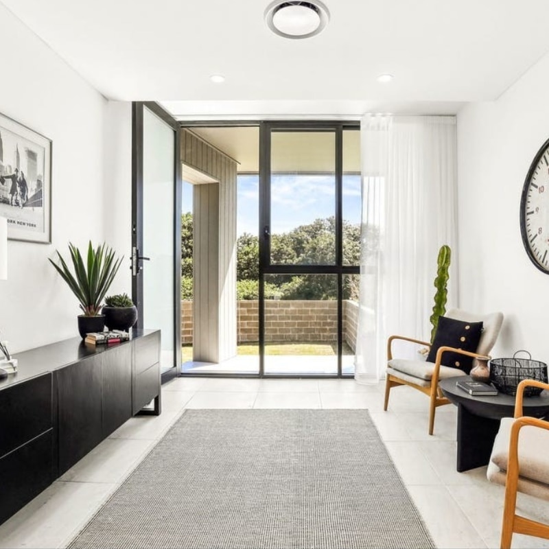 Bright living room at 55 Eyre Street, Chifley, 2036-Duplex with modern decor, indoor plants, large window, laminate flooring, and abundant natural light.