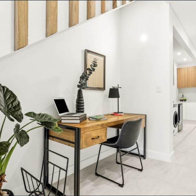 Office table wooden, with black chair featuring minimalist office setup at home – Sydney East Building & Renovations project at 55 Eyre Street, Chifley, 2036-Duplex.