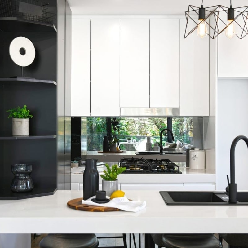 Modern kitchen with white upper cabinets and smart organisers, located at 91 King Street Mascot – built by Sydney East Building & Renovations.