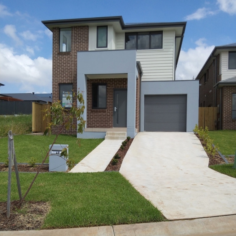 Two-storey house in Leppington featuring brown painted brickwork, grey and white painted finishes, and a spacious landscaped yard.