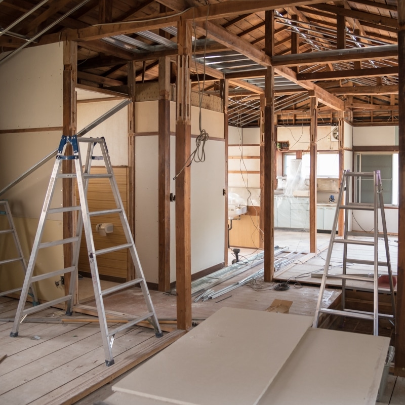 Home renovation Sydney project in progress with professional builders. Renovations. Built for Life. – Unfinished room under renovation with exposed timber beams, ladders, and building materials spread across the floor