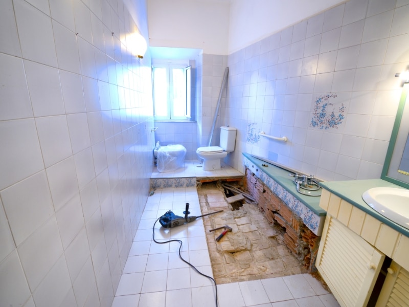 Renovating a bathroom with exposed flooring and tools in use