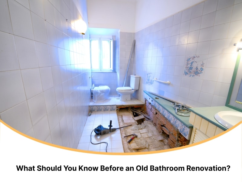 Old bathroom renovation with removed tiles, tools, and toilet in progress.